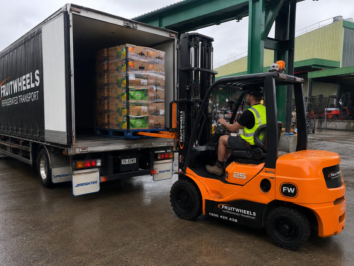 Fruit Wheels forklift loading a pallet of fresh produce cartons for a fruit shop delivery